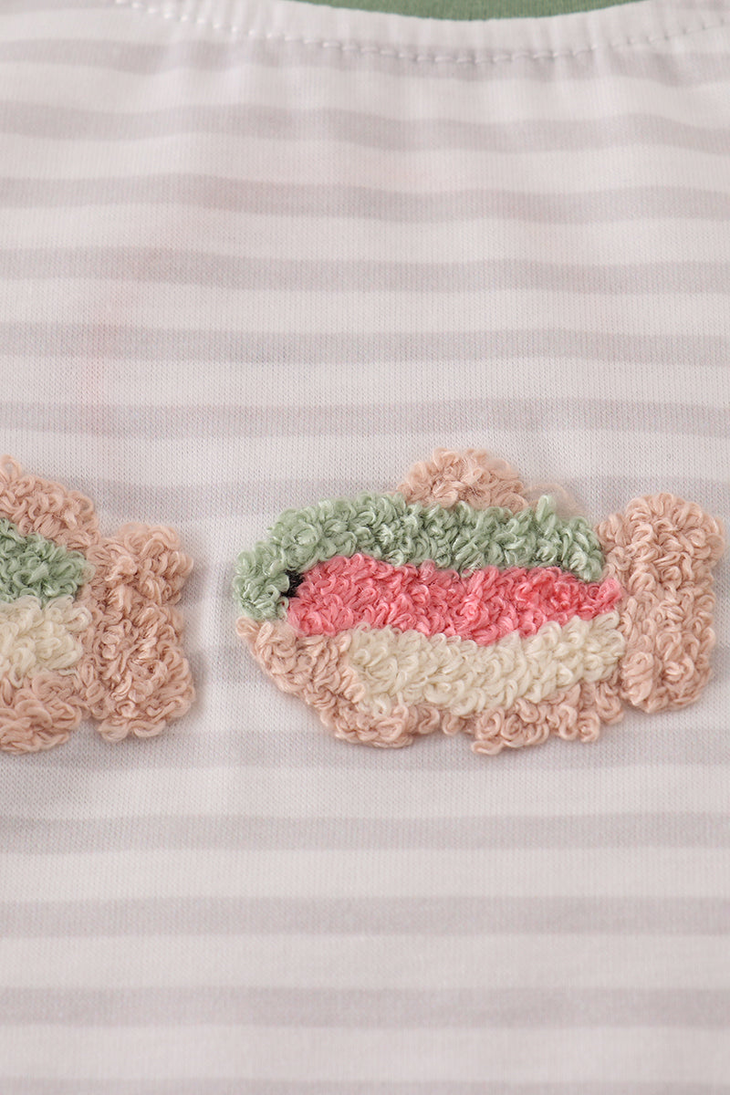Close-up of a striped fabric with textured fish appliqués.