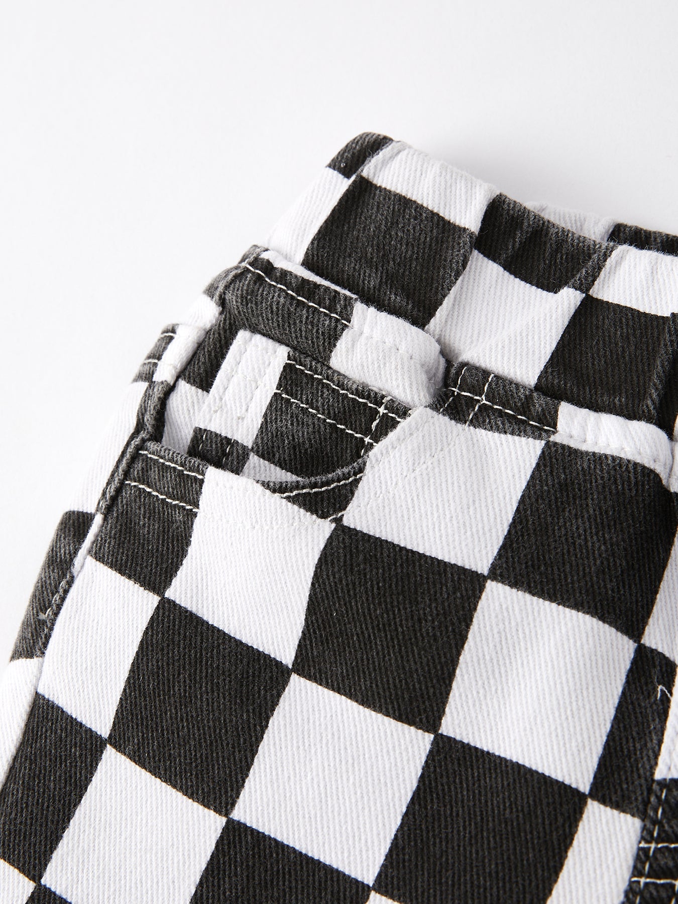 Close-up of black and white checkered pants on a white background