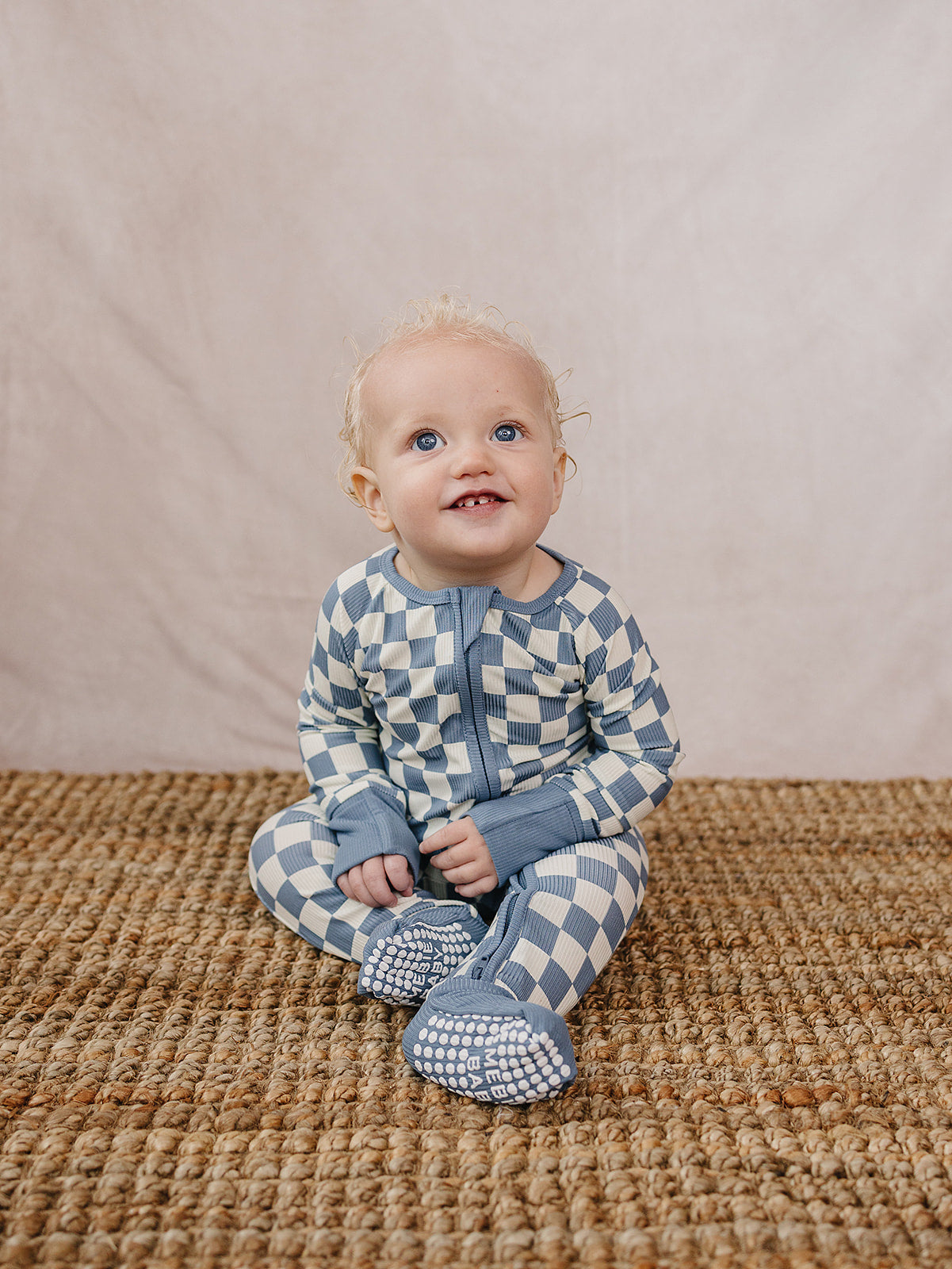 Soft bamboo footed pajamas for baby in blue checkered print, breathable and gentle on sensitive skin
