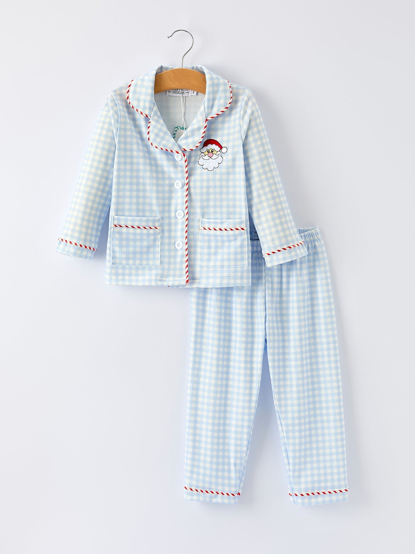 Front view of blue gingham kids Christmas pajama set with embroidered Santa and red candy-cane piping.