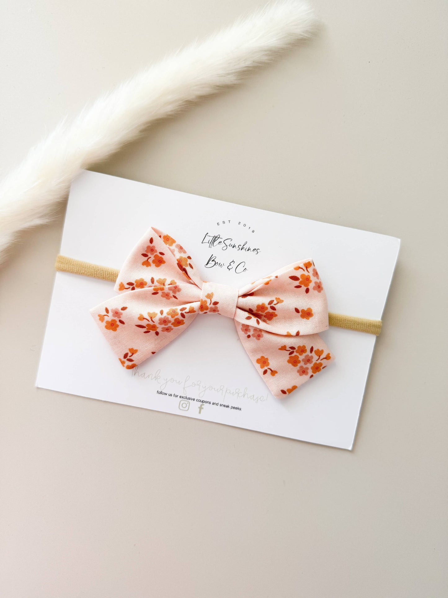 Blush floral baby bow headband on soft nude nylon band for infant girl