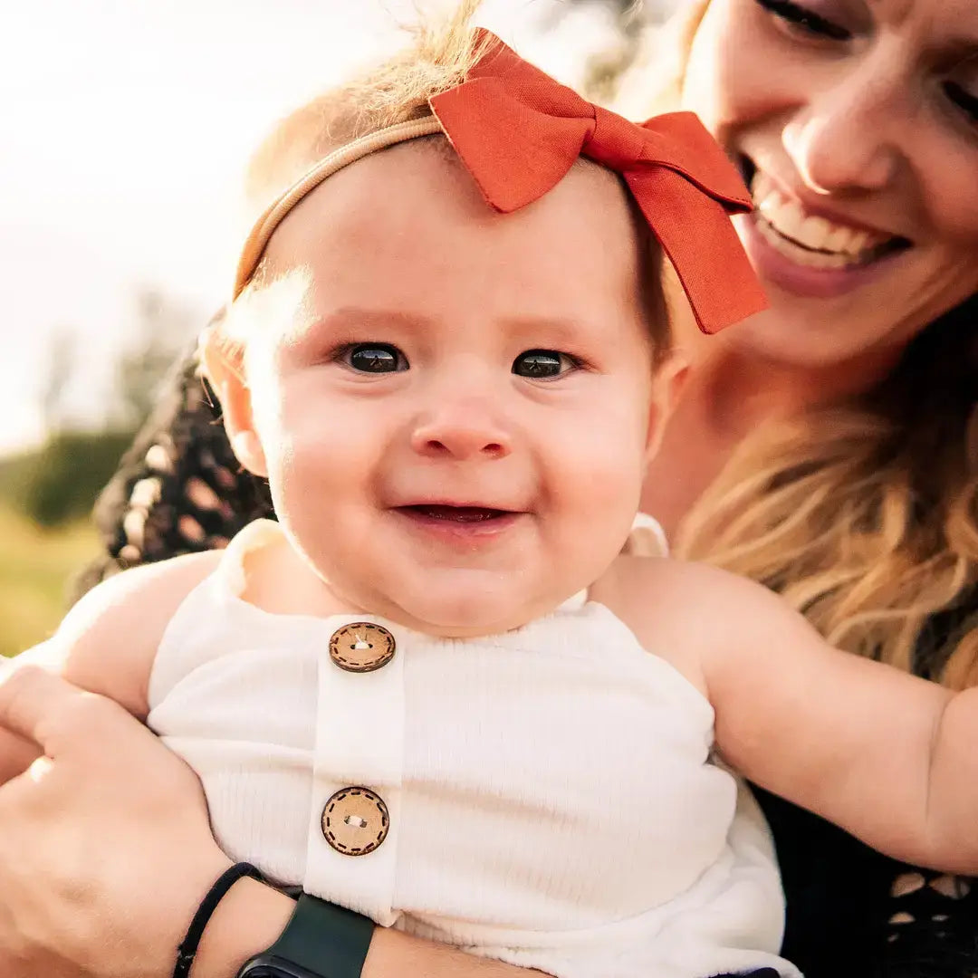 baby wearing a baby bow headband on soft nude nylon band for infant girl