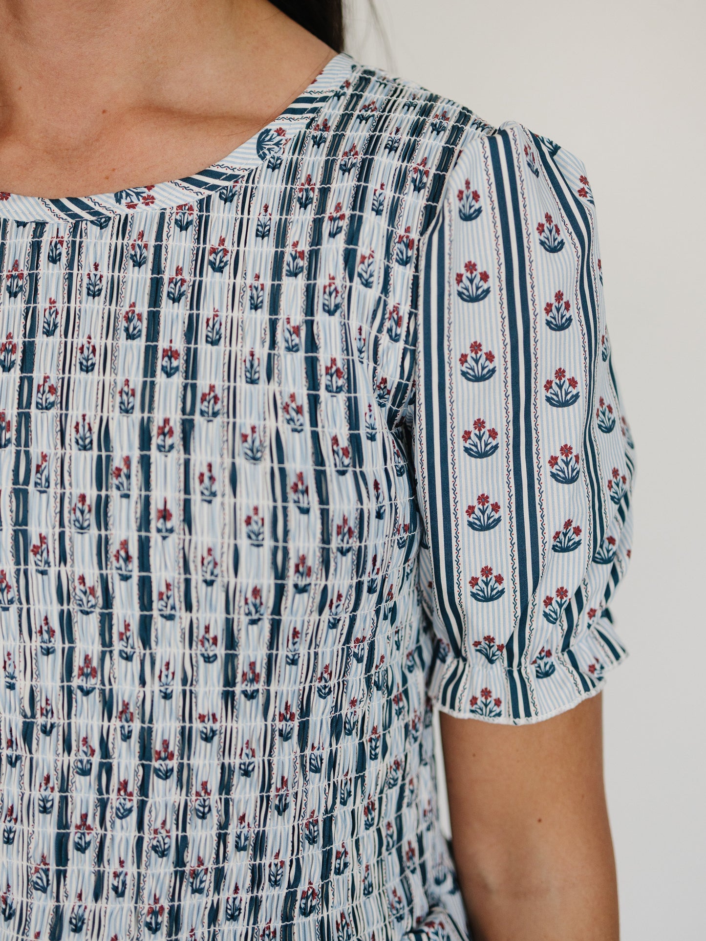 Close-up of a person wearing a patterned dress with floral designs.