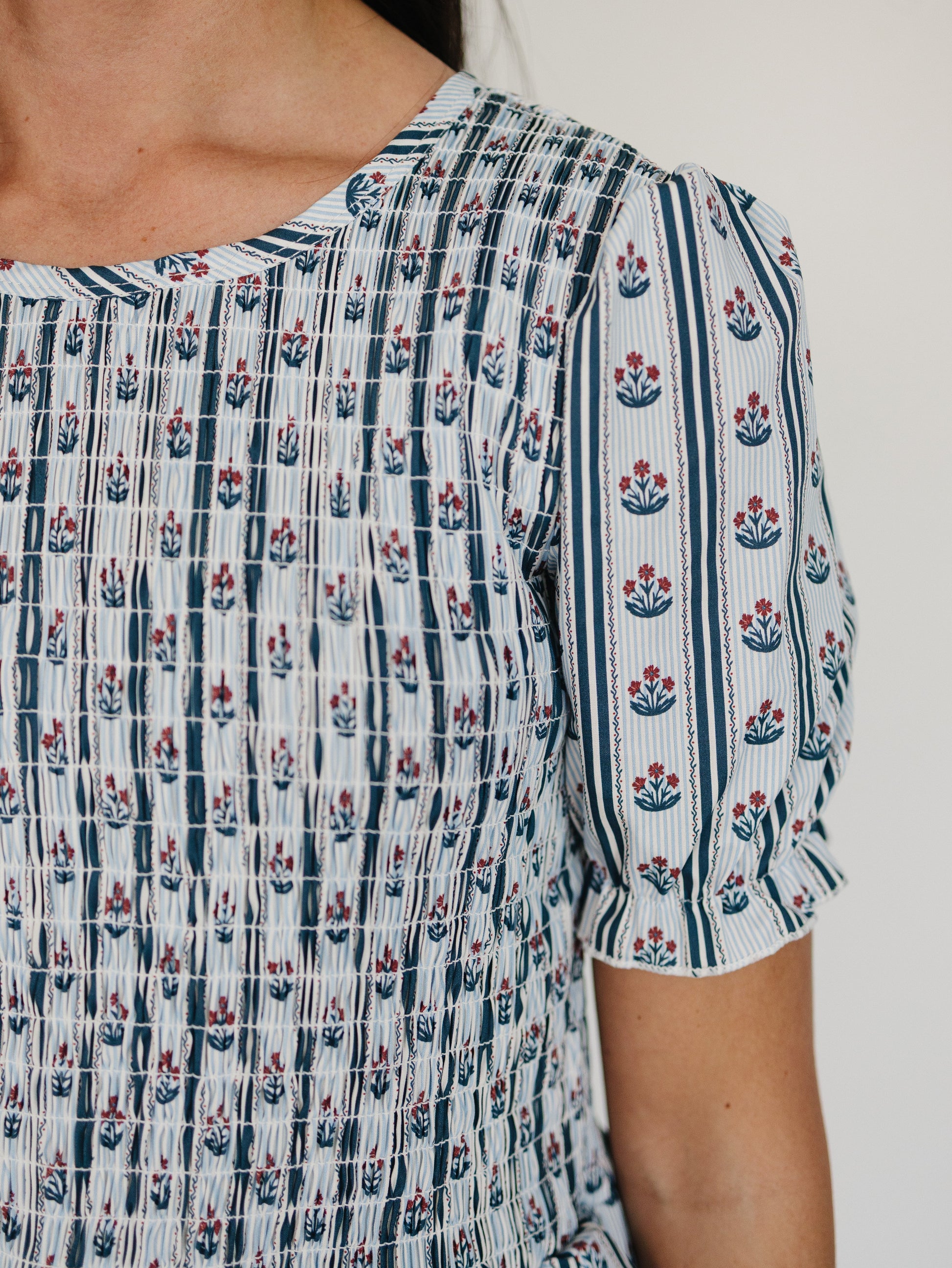 Close-up of a person wearing a patterned dress with floral designs.