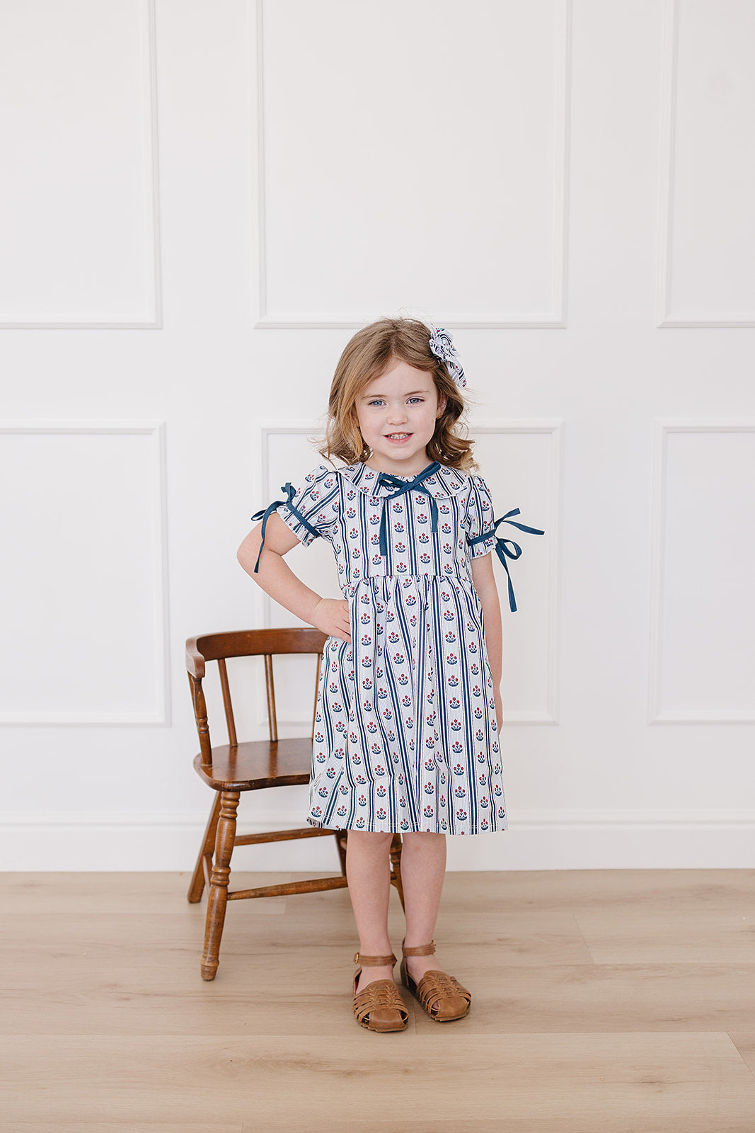 100% cotton floral dress on a toddler girl model with matching bow