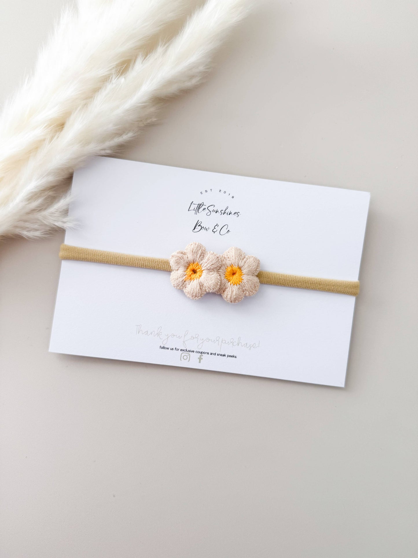 cream daisy knit headband for babies and toddlers with cream petals and yellow center 