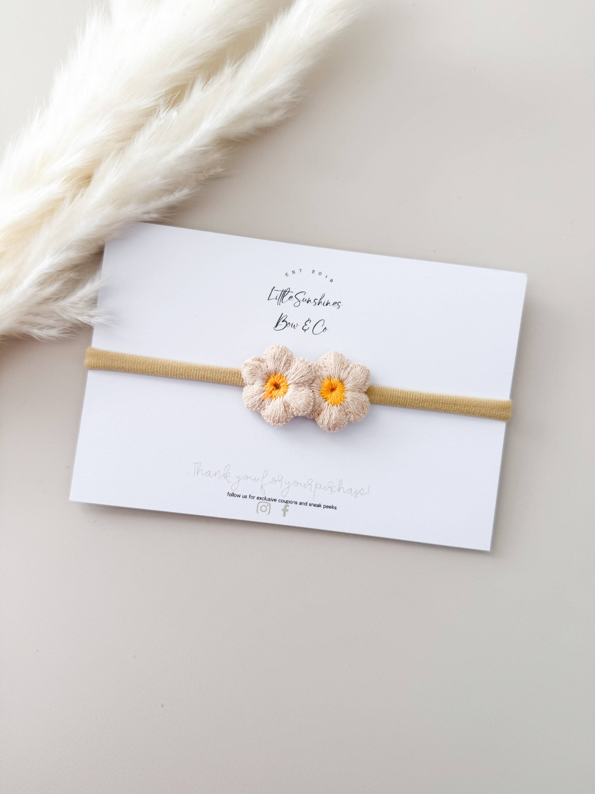 cream daisy knit headband for babies and toddlers with cream petals and yellow center 