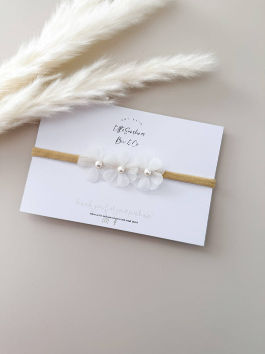 Newborn headband with white tulle bow and pearl accents on stretchy nude band