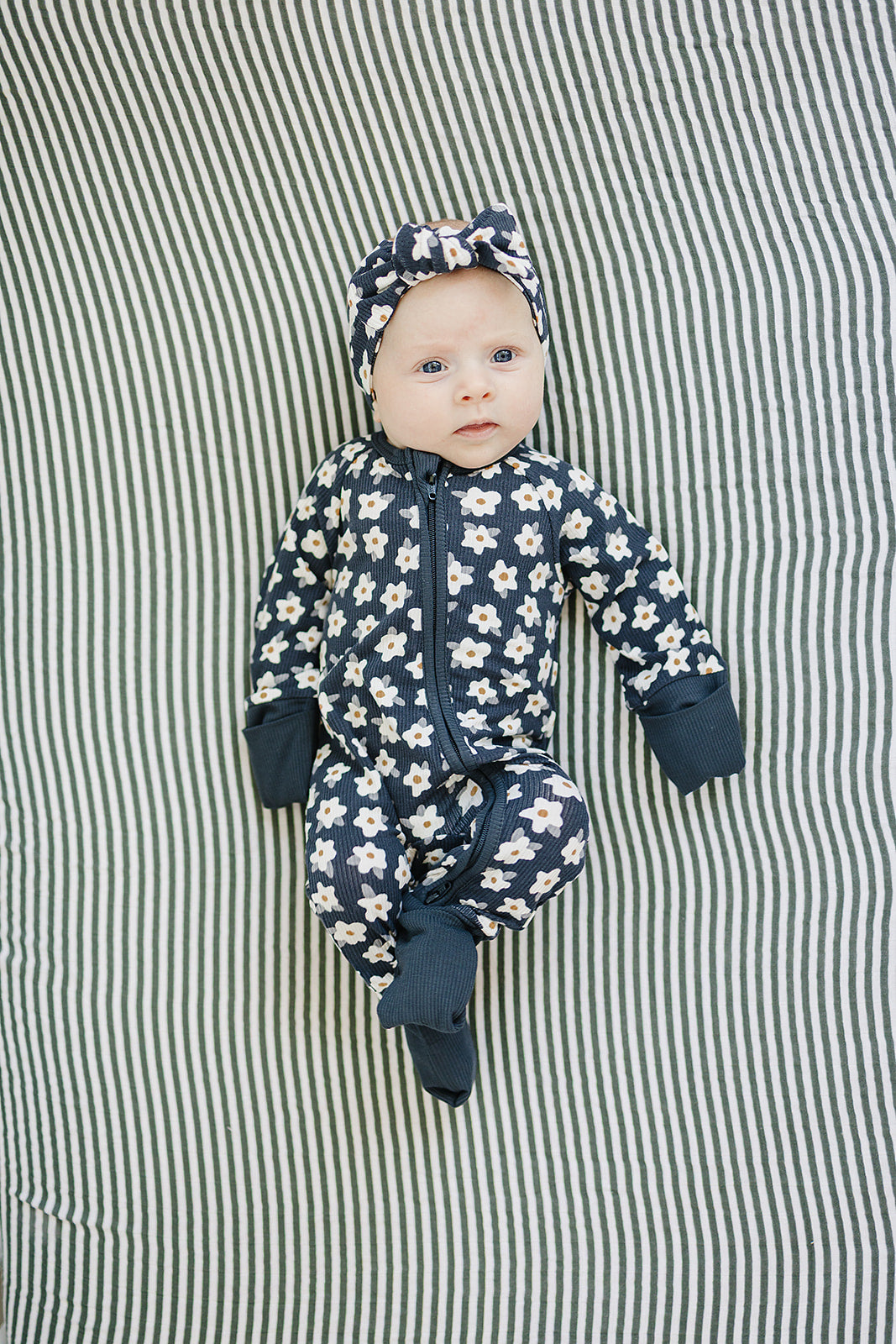Navy daisy print zip-up baby sleeper with fold-over cuffs