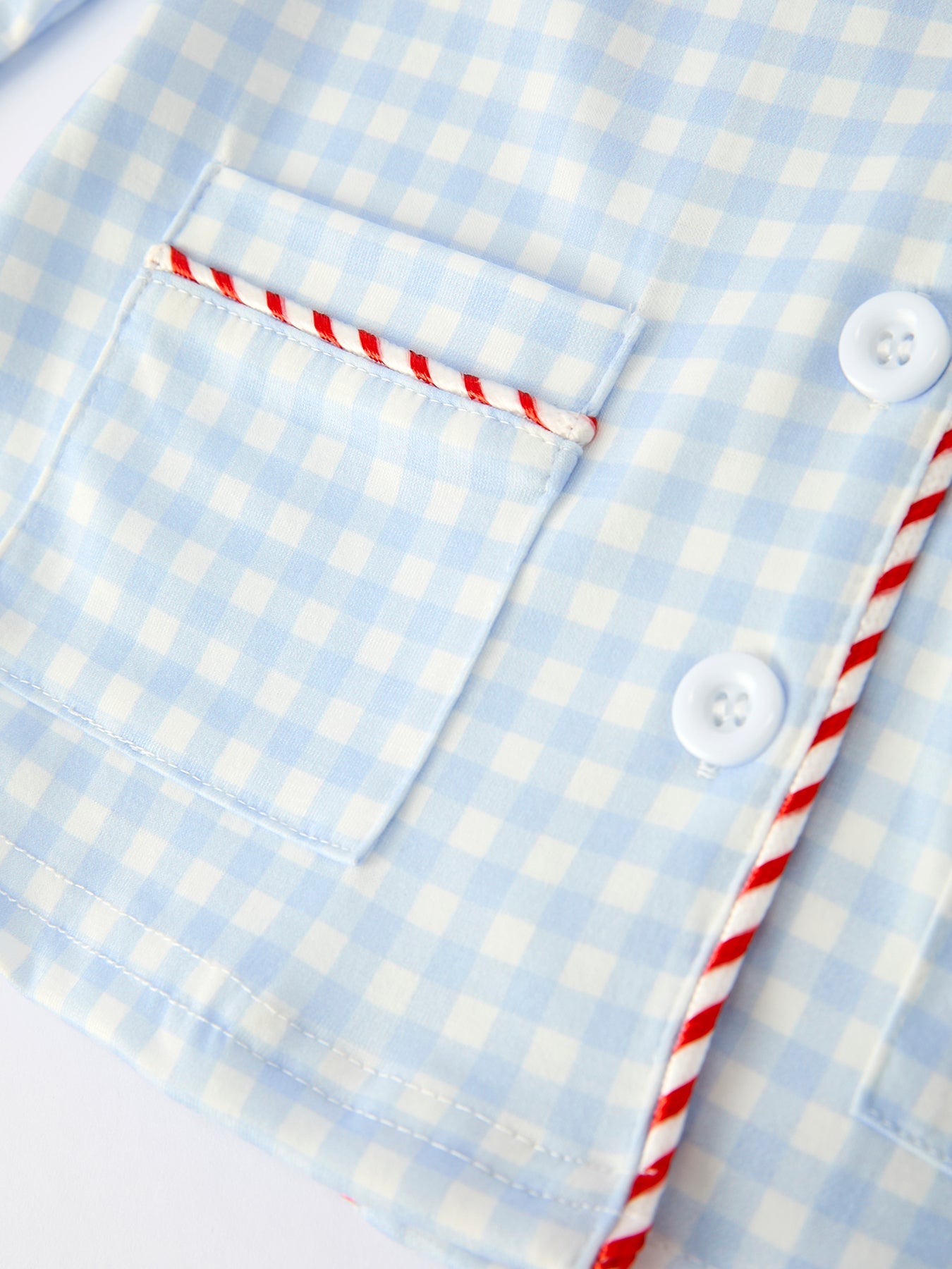 Toddler in blue gingham Santa pajamas perfect for Christmas Eve and family photos.