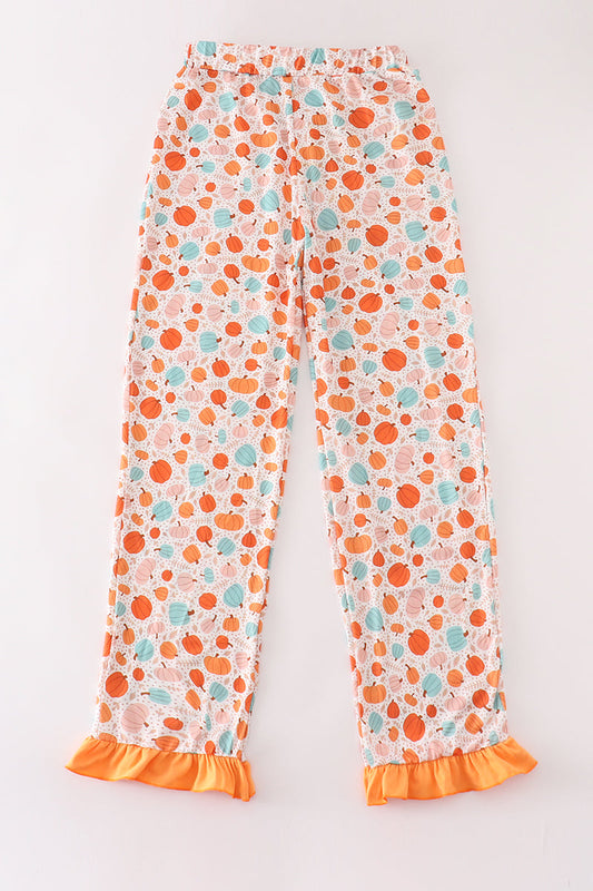 Floral-patterned pants with orange ruffle trim on a white background