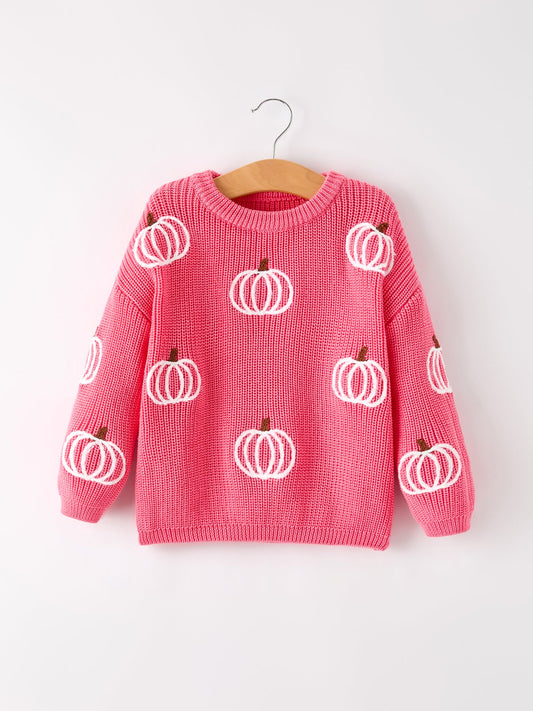 Pink sweater with white pumpkin patterns on a wooden hanger against a white background