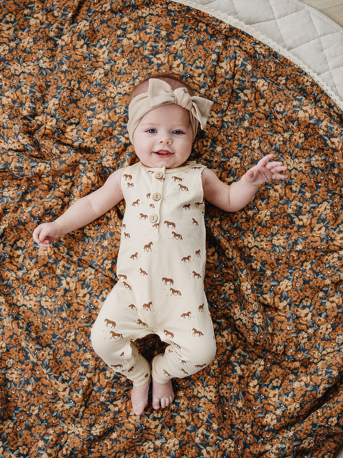 Western horse print detail on neutral baby romper