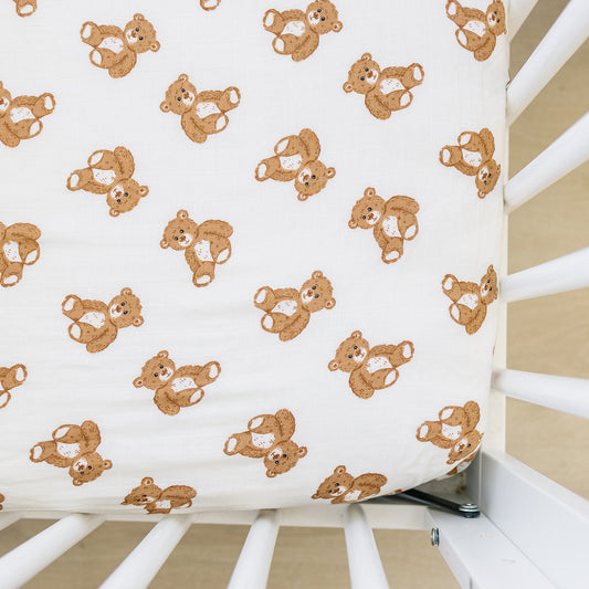 Fitted crib sheet with teddy bear pattern on a crib